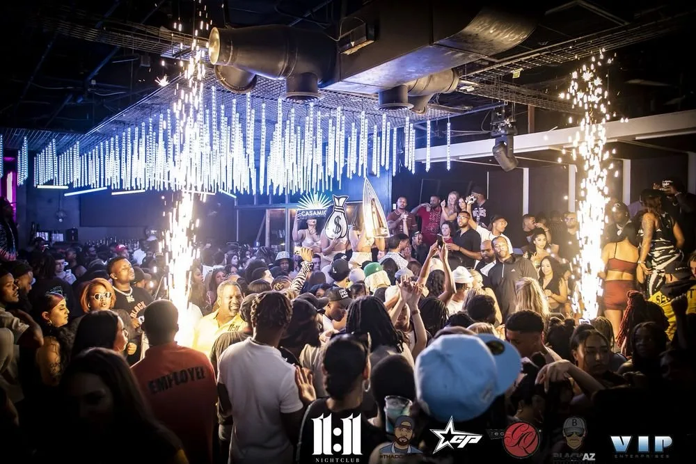 Crowd dancing and partying in a nightclub with pyrotechnics and modern lighting effects.